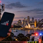 Mobile phone showing no signal beside telecommunications infrastructure and emergency services in Sydney