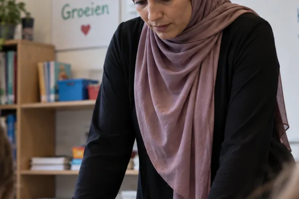 A teacher wearing a hijab in a Belgian classroom, illustrating the East Flanders dismissal over school neutrality rules.