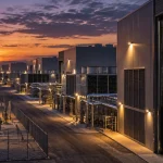 Editorial illustration of a large AI data-centre campus with server racks, electrical substations and transmission infrastructure at dusk.