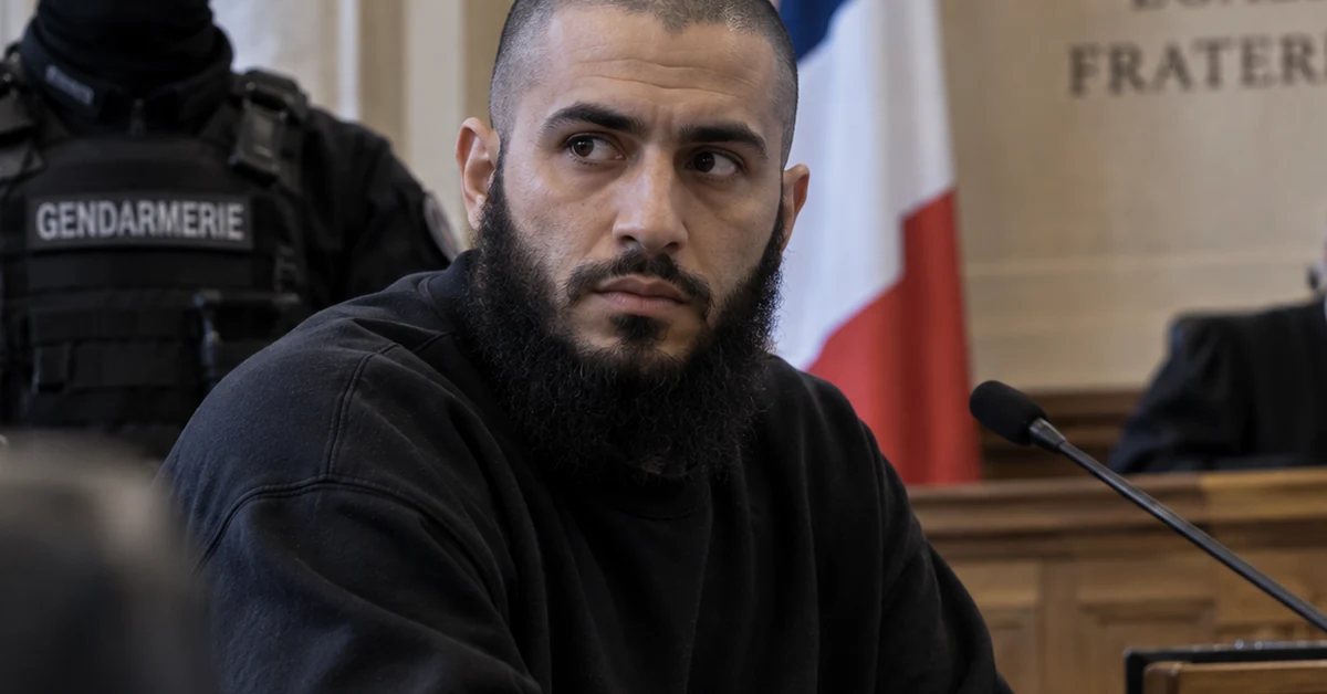 Defendant seated in a French courtroom under guard, illustrating the Paris trial of former Islamic State member Othman Garrido.
