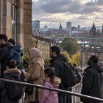 Illustration of people seeking accommodation assistance outside a Glasgow civic building with the city skyline behind them.