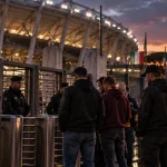 Illustration of police restricting football supporters from entering a stadium in Rome.