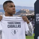 Illustration of Kylian Mbappé holding a Ceuta solidarity shirt before a football match.