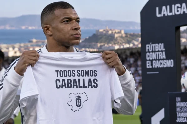 Illustration of Kylian Mbappé holding a Ceuta solidarity shirt before a football match.