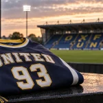 Editorial illustration of an American-style navy and yellow United 93 shirt at a football stadium.