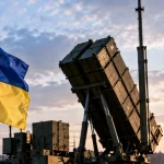 Editorial illustration of Polish and Ukrainian flags beside an air-defence missile launcher representing joint European anti-ballistic development.