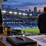 Illustration of a departing football club investor as remaining owners look over a stadium and redevelopment plans.