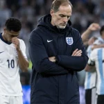 Illustration of Thomas Tuchel and dejected England players after their World Cup semi-final defeat to Argentina.