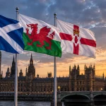 Scottish, Welsh and Northern Irish flags flying in front of the Palace of Westminster at sunset